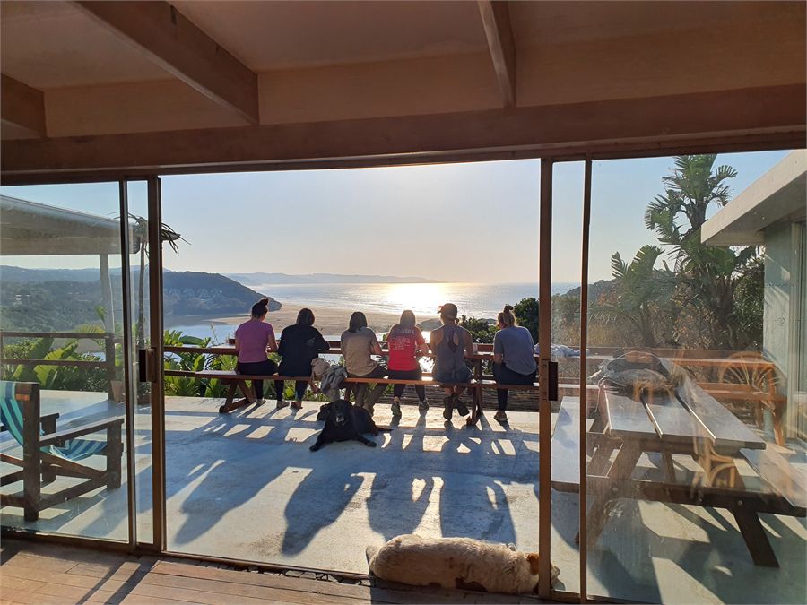Guests having breakfast on the verandah overlooking the bay