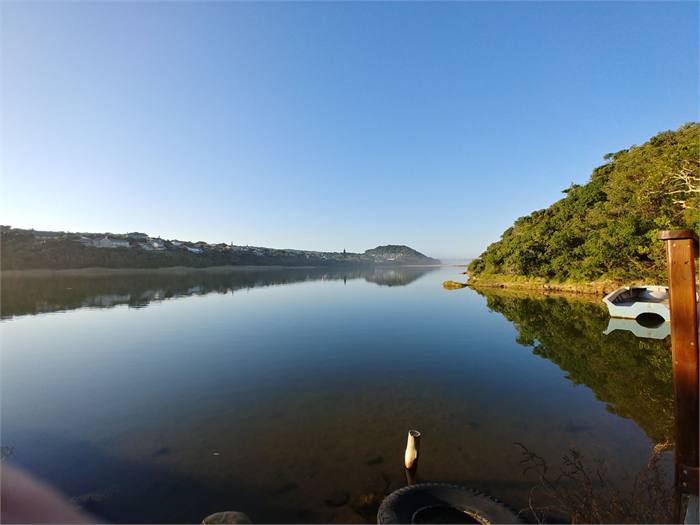 Clear still water on the Chintsa lagoon reflecting the hillside