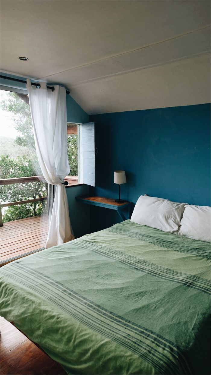 The budget double cabin with a green bedspread and doors open to the deck
