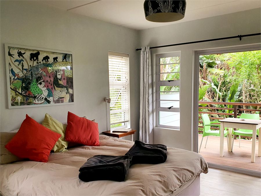 Tree house garden-view en-suite bedroom with doors opening onto a deck