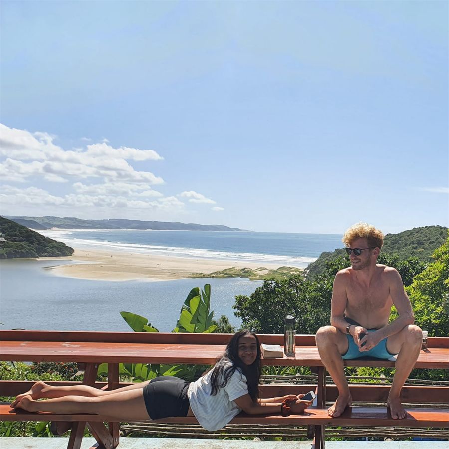 Guests relaxing on a deck at Buccaneers with the beach and sea behind them